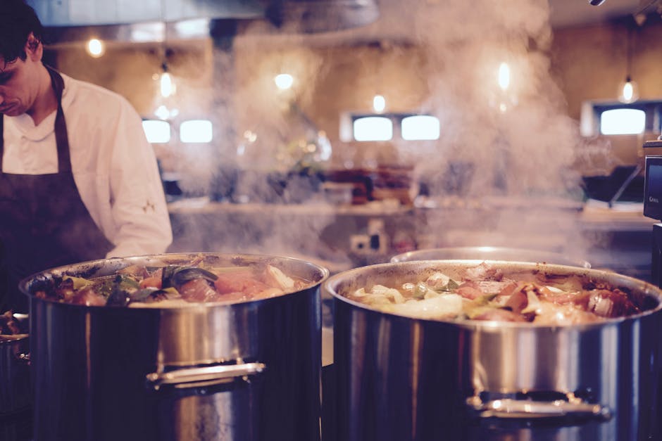 Pressure cooker with steam releasing and finished meal beside it.