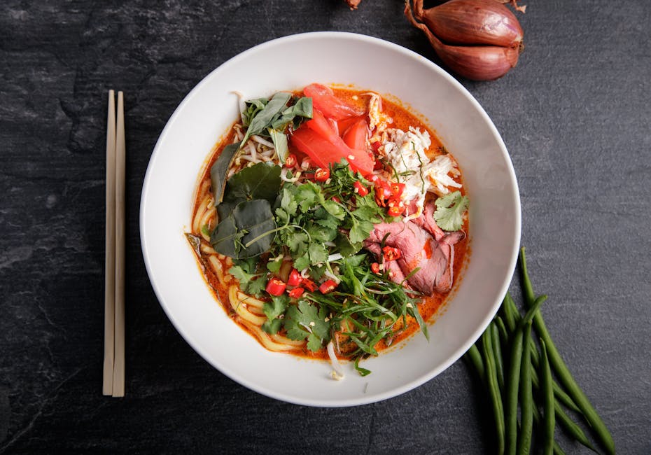 Colorful Thai curry and noodle dishes served in traditional bowls.